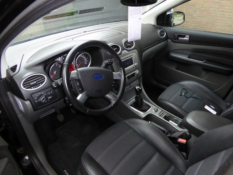 Schoon interieur van een Ford met lederen stoelen.
